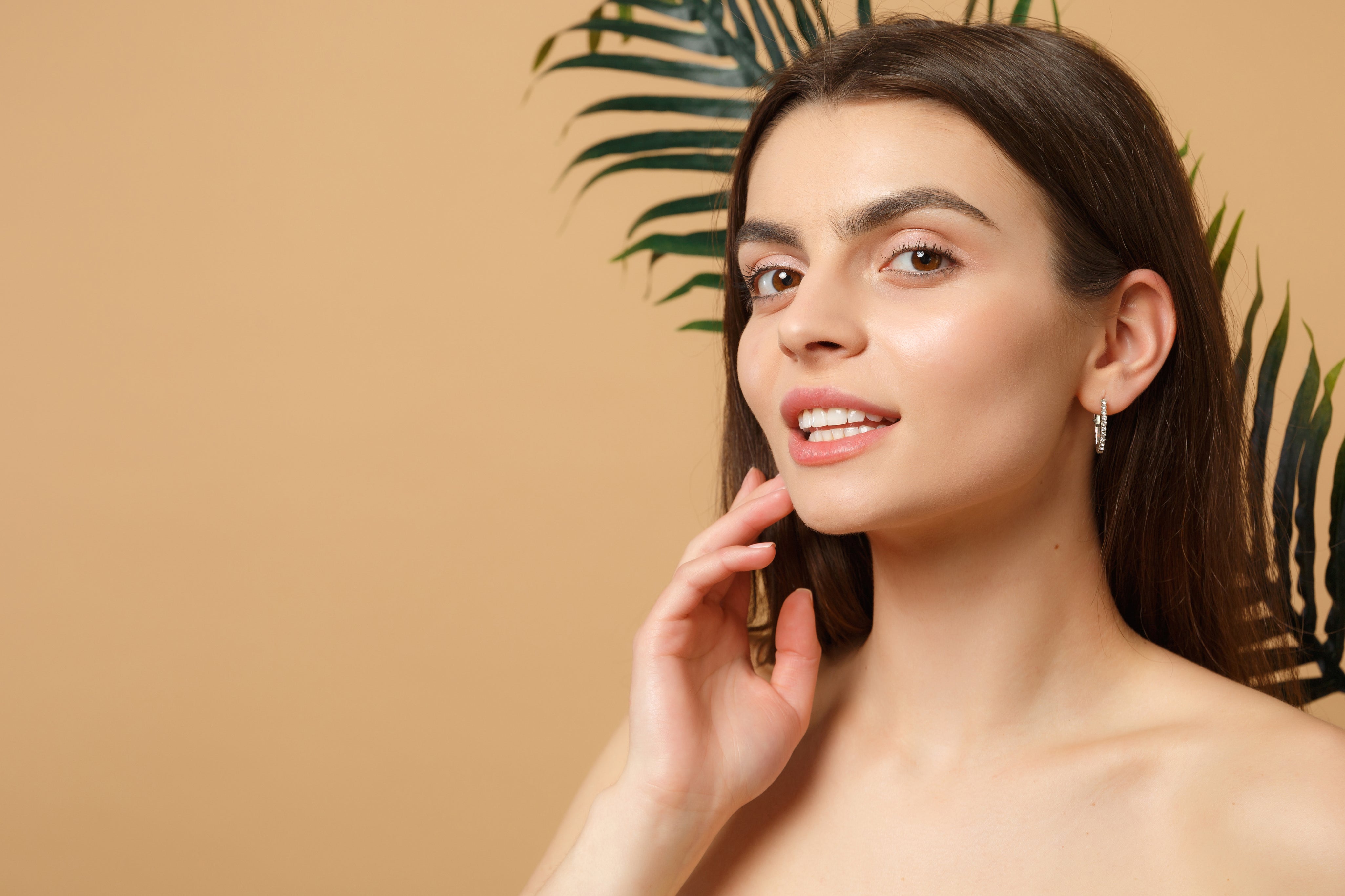 close-up-brunette-half-naked-woman-with-perfect-skin-nude-make-up-palm-leaf-isolated-beige-pastel-wall_1_copy.webp